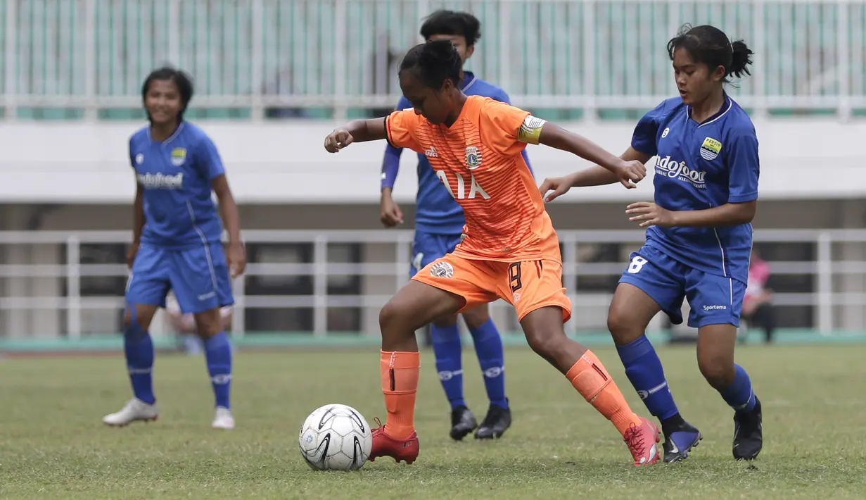 Gelandang Persija Jakarta Putri, Viny Silvianus, berebut bola dengan pemain Persib Bandung pada laga lanjutan Liga 1 Putri 2019 di Stadion Pakansari, Bogor, Kamis (7/11). Persib Putri menang 2-1 atas Persija Putri. (Bola.com/Yoppy Renato)