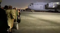 Orang-orang Afghanistan mengantre dan menaiki pesawat militer AS untuk meninggalkan Afghanistan, di bandara militer di Kabul, Kamis (19/8/2021). Ribuan orang berlomba-lomba melarikan diri dari Afghanistan setelah pasukan Taliban berhasil merebut pemerintahan negara itu. (Shakib RAHMANI/AFP)