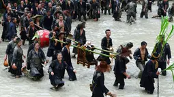 Sekelompok orang dari etnis Miao membawa anjing diletakan di kursi saat festival dog carrying day di provinsi Guizhou, Tiongkok (2/9). Acara ini juga bertujuan memberikan rasa hormat kepada semua makhluk. (AFP Photo/STR/China Out)