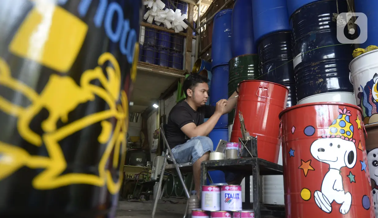 Faiz (21) melukis tong sampah dengan gambar tokoh kartun di Setu, Tangerang Selatan, Banten, Kamis (1/10/2020). Faiz mengecat ulang tong bekas dan melukisnya dengan tokoh-tokoh kartun, lalu menjualnya dengan harga Rp 85 hingga 120 ribu per unit. (merdeka.com/Dwi Narwoko)
