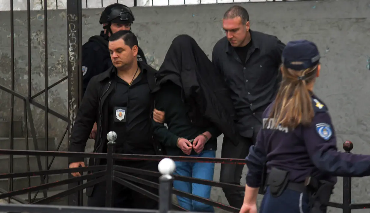 Seorang tersangka dikawal polisi di luar sekolah Vladislav Ribnikar di Beograd, Serbia, Rabu (3/5/2023). Seorang anak laki-laki berusia 13 tahun menembak mati delapan siswa dan seorang penjaga keamanan di sebuah sekolah di Beograd pada Rabu, 3 Mei 2023. (AP Photo)