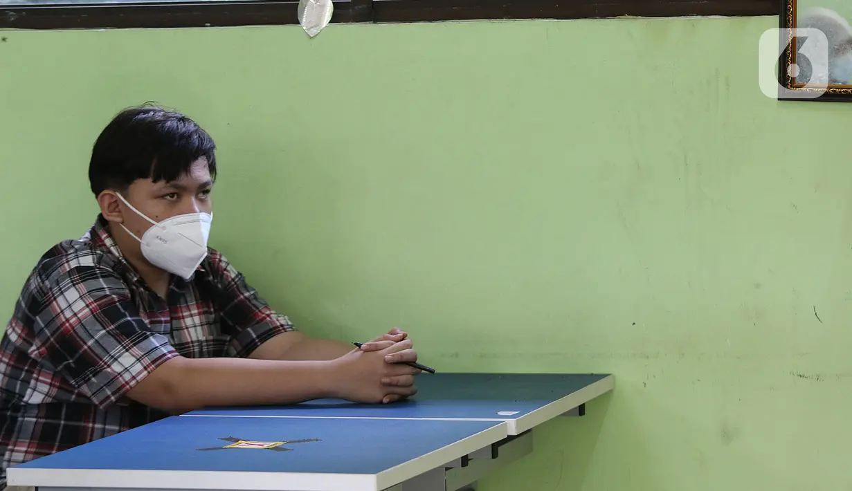 Seorang siswa mengikuti kegiatan belajar tatap muka di SMP Negeri 2 Bekasi, Selasa (23/3/2021). Kegiatan belajar mengajar secara tatap muka di SMPN 2 Kota Bekasi hanya diikuti oleh 50 persen siswa. (Liputan6.com/Herman Zakharia)