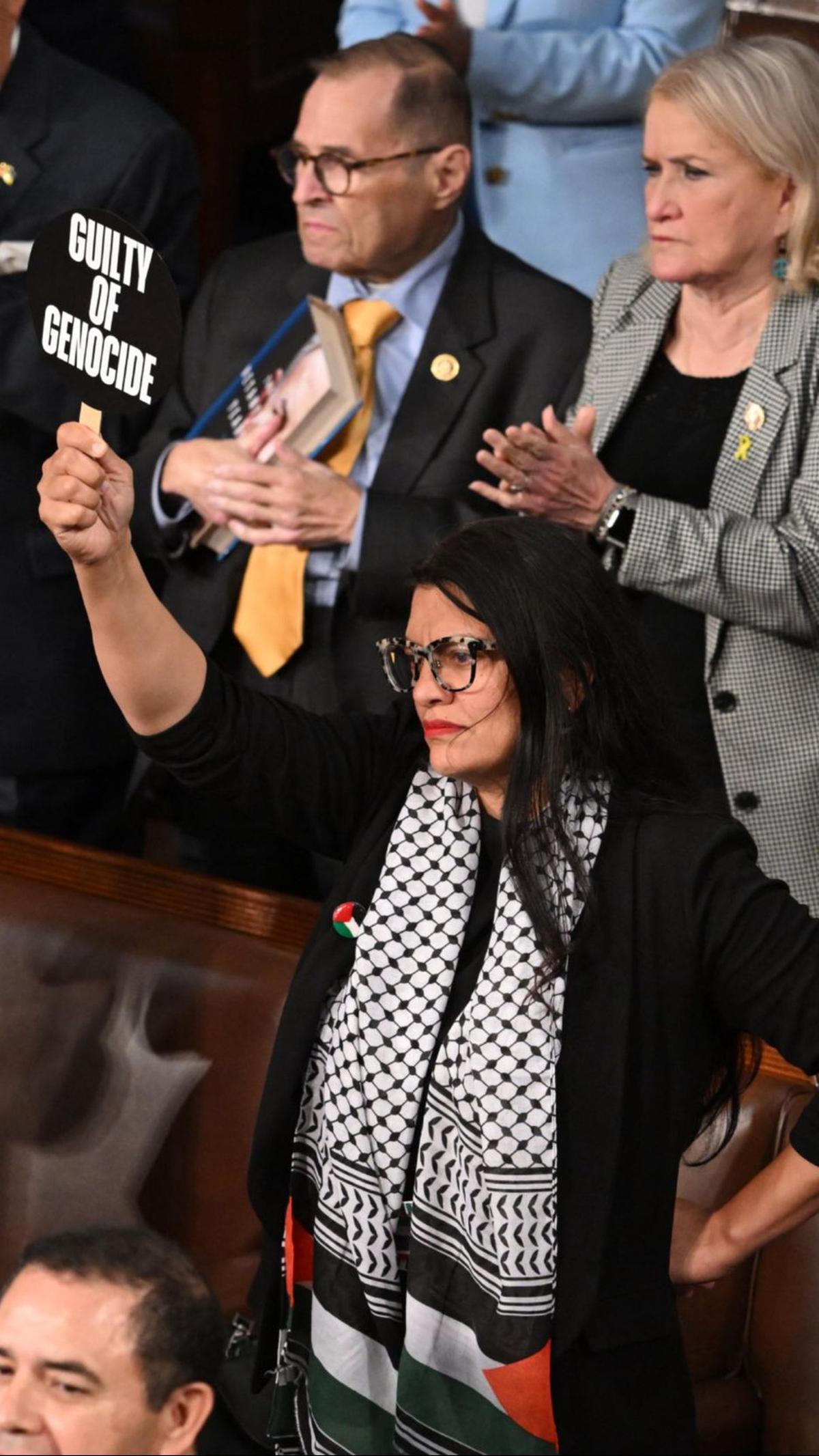 Selain itu, perempuan yang tampil mengenakan Keffiyeh khas Palestina ini juga mengangkat plakat bertuliskan 'Bersalah atas Genosida'.&nbsp;Foto: AFP