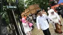 Pengantin Mansur dan Maya melintasi banjir usai melakukan akad nikah di KUA Mampang Prapatan, Jakarta, Selasa (21/2). Walaupun banjir sepasang pengantin ini tetap melakukan akad nikah. (Liputan6.com/Herman Zakharia)