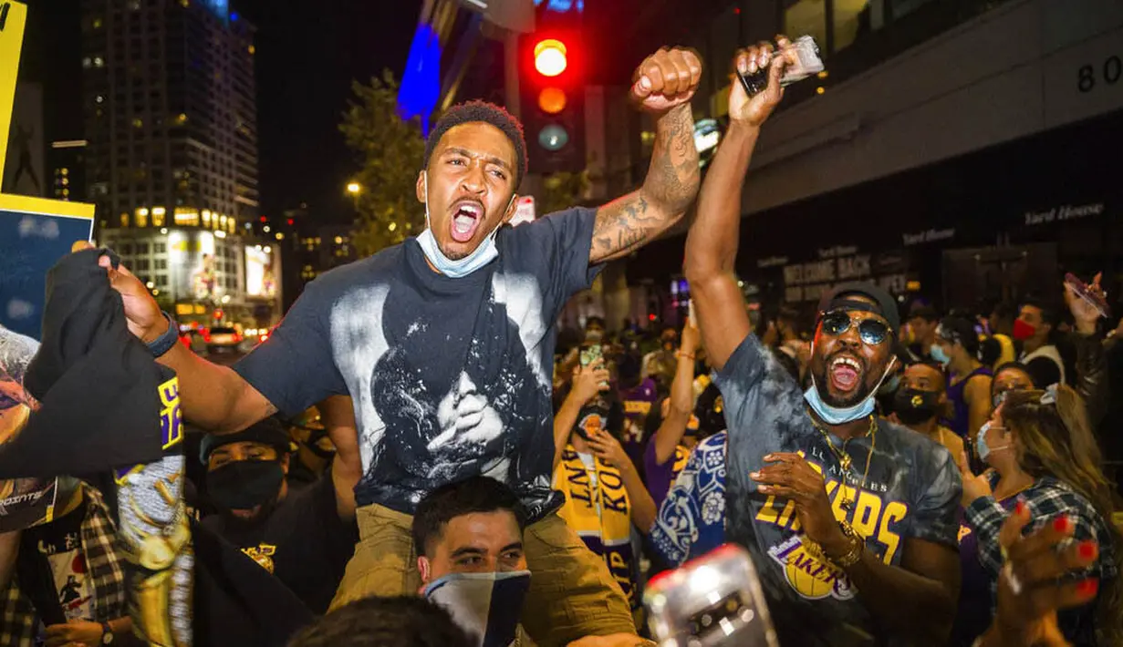 Fans LA Lakers melakukan selebrasi turun ke jalan usai menjuarai NBA 2020 di Los Angeles, Senin (12/10/2020).
LA Lakers menjadi juara NBA 2020 setelah mengalahkan Miami Heat dengan skor 106-93 dalam final gim ke enam. (AP Photo/Jintak Han)