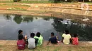 Anak-anak bermain di sekitar bantaran Kanal Banjir Timur (KBT), kawasan Cipinang Muara, Jakarta, Selasa (16/6/2020). Sebagian besar warga masih mengabaikan protokol kesehatan dengan tidak menjaga jarak serta tanpa menggunakan masker. (Liputan6.com/Immanuel Antonius)