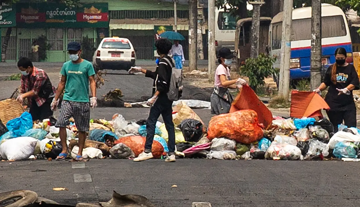 Pengunjuk rasa membuang sampah di jalan untuk membentuk barikade darurat selama demonstrasi menentang kudeta militer di kota Thaketa Yangon, Myanmar, Selasa (30/3/2021). "Serangan sampah" menjadi taktik baru pengunjuk rasa Myanmar untuk melawan junta militer. (AFP/FACEBOOK)