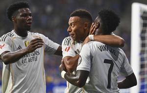 Kylian Mbappe dari Real Madrid (tengah) mendapat ucapan selamat dari rekan-rekannya, Vinicius Junior (kanan) dan Aurelien Tchouameni, setelah mencetak gol dalam laga La Liga antara Real Oviedo dan Real Madrid di Stadion Carlos Tartiere, Oviedo, Spanyol, Minggu, 24 Agustus 2025. (AP Photo/Miguel Oses)