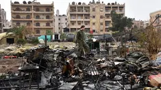 Tentara Rusia berdiri di puing-puing dari rumah sakit lapangan militer Rusia yang diserang pemberontak oposisi Suriah di Aleppo, Senin (5/12). Serangan ini menewaskan seorang petugas medis militer perempuan dan melukai dua lainnya. (GEORGE OURFALIAN/AFP)