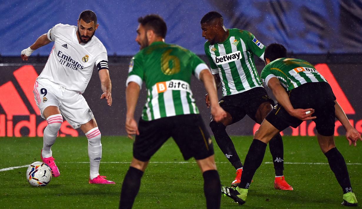 Striker Real Madrid, Karim Benzema (kiri) menguasai bola di depan tiga pemain Real Betis dalam laga lanjutan Liga Spanyol 2020/2021 pekan ke-33 di Alfredo Di Stefano Stadium, Madrid, Sabtu (24/4/2021). Real Madrid bermain imbang 0-0 dengan Real Betis. (AFP/Gabriel Bouys)