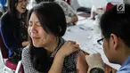 Ekspresi Mahasiswi saat disuntik vaksin difteri di Universitas Tarumanegara, Jakarta, Kamis (14/5). Ratusan mahasiswa/wi yang berusia di bawah 19 tahun mendapatkan imunisasi (Td) sebagai antisipasi mewabahnya penyakit difteri. (Liputan6.com/Faizal Fanani)