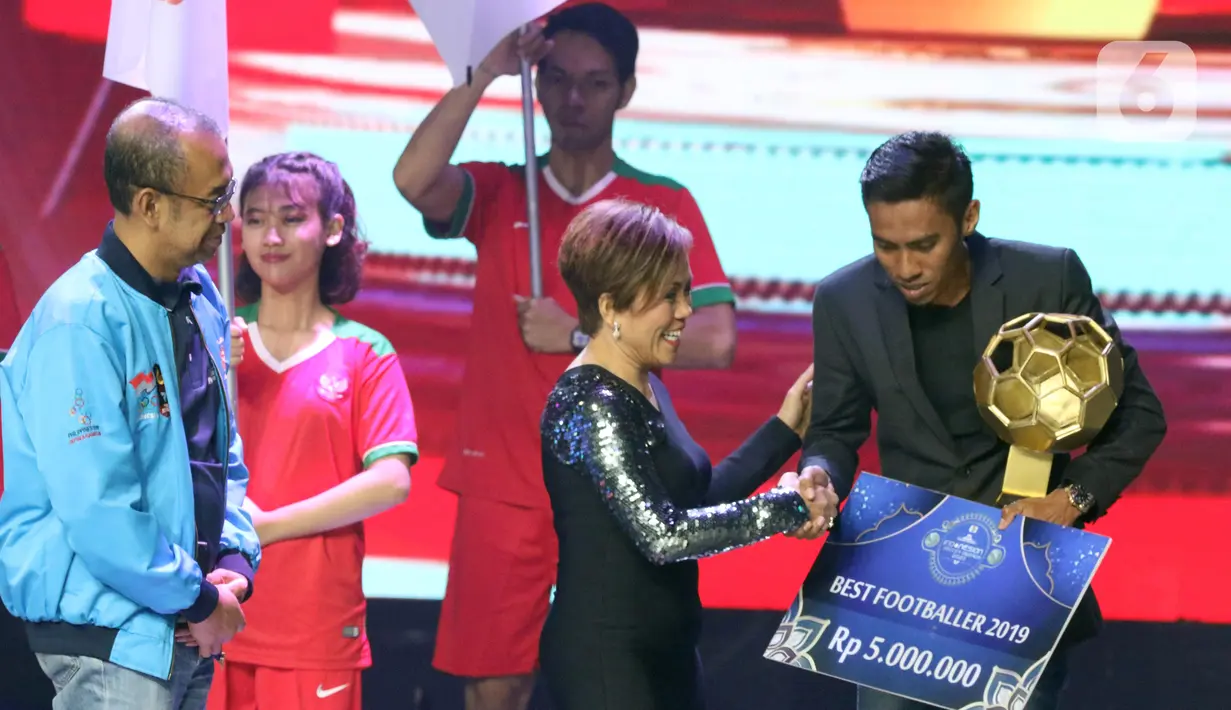Direktur Program SCM, Harsiwi Achmad (kedua kanan) menyerahkan hadiah kepada Fadil Sausu, pemain Bali United yang terpilih sebagai Best Footballer 2019 saat Indonesian Soccer Award 2019 di Studio 6 Indosiar, Jakarta, Jumat (10/1/2020). (Liputan6.com/Helmi Fithriansyah)