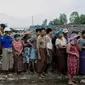Dalam foto yang diambil pada 21 Mei 2021 ini, orang-orang menunggu untuk menerima kantung beras yang didistribusikan oleh Program Pangan Dunia (WFP) sebagai bagian dari upaya bantuan pangan untuk mendukung warga yang tinggal di komunitas miskin di pinggiran Yangon. (Foto: AFP / STR)