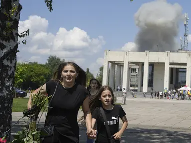 Sebuah keluarga lari dari ledakan setelah serangan roket Rusia di lingkungan perumahan di Pervomaiskyi, wilayah Kharkiv, Ukraina, Selasa, 4 Juli 2023. (AP Photo/Oleksandr Magula)