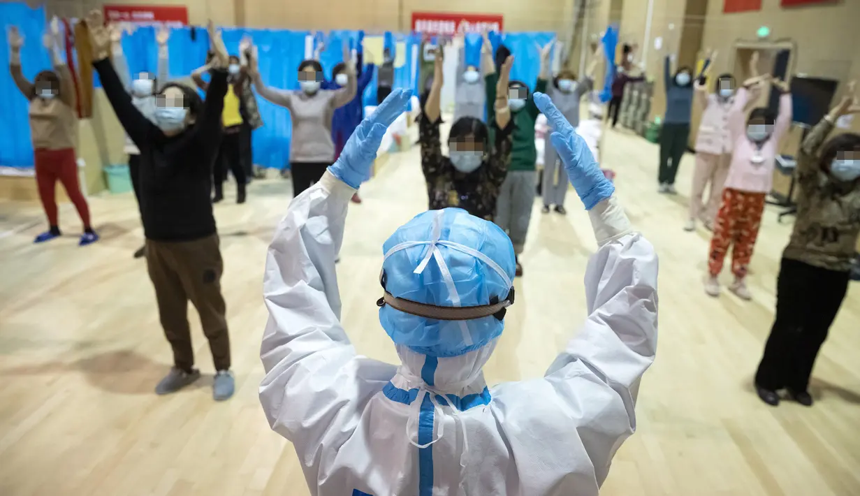 Petugas medis Yi Qin menjadi instruktur kebugaran fisik tradisional China untuk pasien COVID-19 di rumah sakit sementara di Distrik Jiangxia, Wuhan, Hubei, China (25/2/2020). Gelombang pertama sebanyak 23 pasien diizinkan pulang setelah menggunakan pengobatan tradisional China. (Xinhua/Shen Bohan)