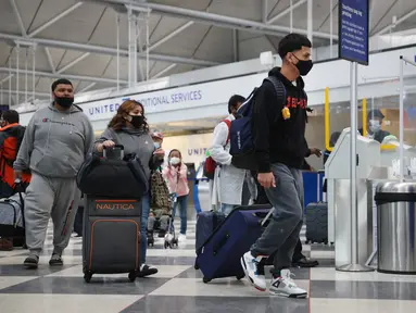 Wisatawan tiba untuk penerbangan di Bandara Internasional O'Hare di Chicago, Illinois pada 16 Maret 2021. Langkah vaksinasi COVID-19 di AS terus berlangsung hingga hari ini dan hal tersebut pun berdampak pada sektor perjalanan, termasuk perjalanan udara. (Scott Olson/Getty Images/AFP)