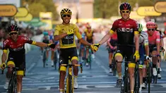 Pebalap Kolombia Egan Bernal (tengah) berpegangan tangan dengan Geraint Thomas setelah memenangkan balap sepeda Tour de France 2019, Paris, Prancis, Minggu (28/7/2019 ). Egan Bernal menjuarai Tour de France 2019 setelah menempuh perjalanan lebih dari 3,409 km. (AP photo/Michel Euler)