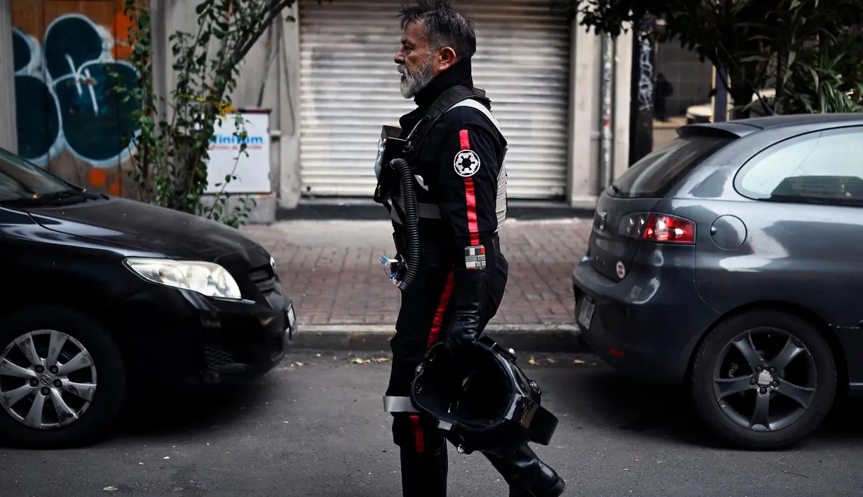 Seorang penggemar cerita dan film Star Wars mengenakan kostum saat parade yang disebut "Hari Pelatihan" di Paseo de la Reforma, Meksiko, pada Sabtu 15 Oktober 2022. Beragam kostum bertema Star Wars dikenakan para penggemar dalam parade tersebut. (ALFREDO ESTRELLA/AFP)