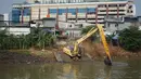 Alat berat mengeruk sampah bercampur lumpur di aliran Banjir Kanal Barat, Jakarta, Rabu (14/10/2020). Pengerukan serta pembersihan waduk, sungai, dan saluran air dari lumpur juga sampah untuk mencegah pendangkalan serta mengantisipasi banjir saat musim hujan. (Liputan6.com/Immanuel Antonius)