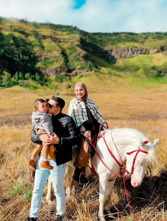 OOTD Zaskia Sungkar saat ke Gunung Bromo ini bisa jadi inspirasi. Padukan plaid cape dengan inner putih dan celana plisket warna turmeric. Untuk hijab, kamu bisa pilih palet warna bumi seperti coklat. (Instagram/irwansyah14).