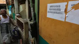 Tulisan protes terhadap penggusuran ditulis di tembok rumah warga di kawasan pemukiman Kampung Pulo, Jakarta Timur, Kamis (23/7). Pemerintah Provinsi DKI Jakarta akan menertibkan bangunan liar yang ada di wilayah Kampung Pulo. (Liputan6.com/Faizal Fanani)