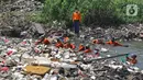 Sejumlah petugas DLH mendorong sampah yang memenuhi Kali Busa untuk dikeruk menggunakan ekskavator di Tambun Utara, Kabupaten Bekasi, Jawa Barat, Jumat (10/9/2021). Pengerukan sampah ditargetkan selesai selama dua hari dan selanjutnya dipindahkan ke TPA Burangkeng. (Liputan6.com/Herman Zakharia)