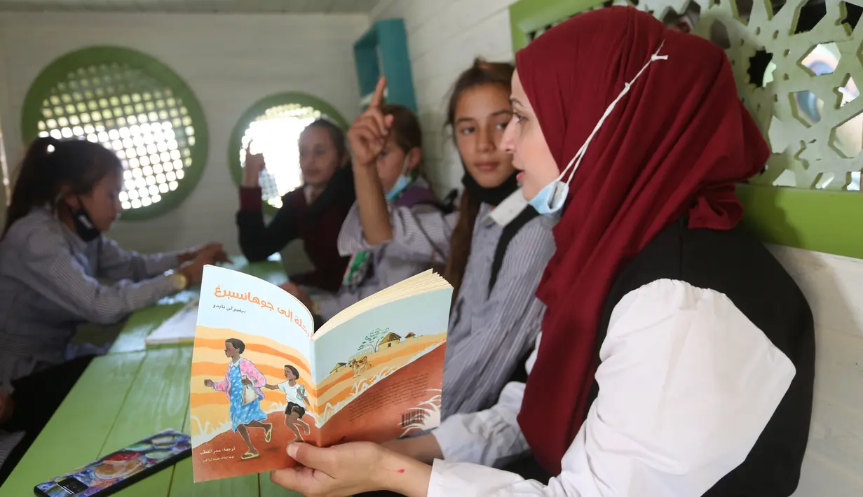Para siswa Palestina duduk dalam bus yang telah dialihfungsikan menjadi ruang kelas keliling di Khirbet Ibziq, dekat Kota Tubas, Tepi Barat, 8 Oktober 2020. Sebuah asosiasi lokal mengalihfungsikan sebuah bus menjadi perpustakaan dan ruang kelas keliling. (Xinhua/Ayman Nobani)