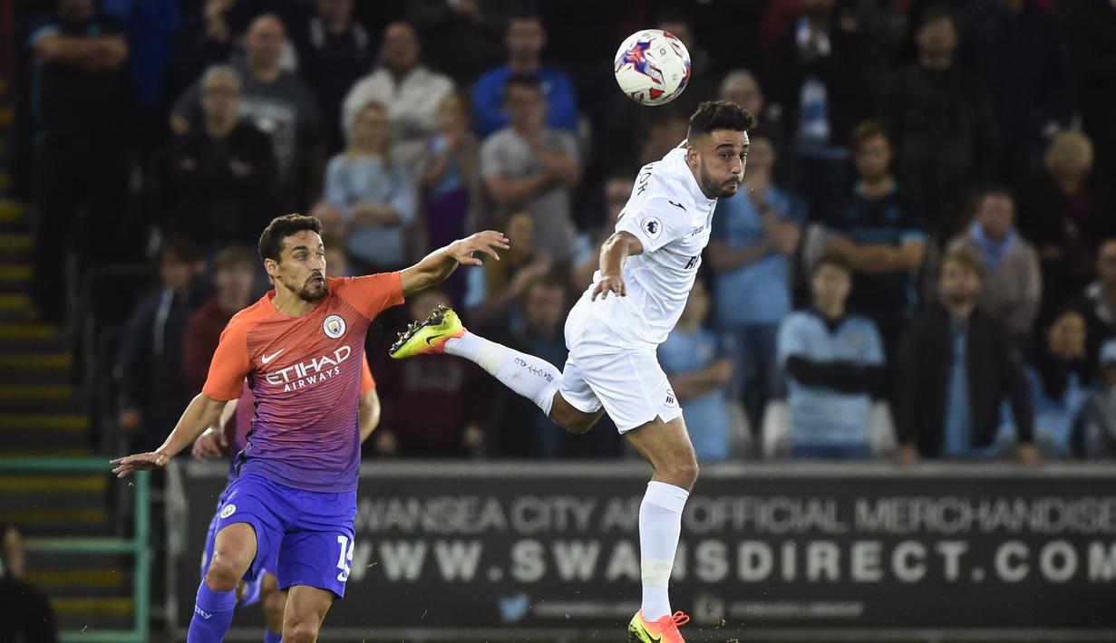 Pemain Machester City, Jesus Navas mencoba menghadang  pemain Swansea City, Neil Taylor pada laga Piala Liga Inggris di Liberty Stadium, Kamis (22/9/2016) dini hari WIB.  (Reuters/Rebecca Naden)