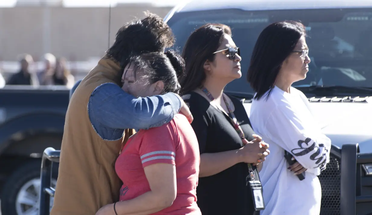 Keluarga menyaksikan polisi melakukan penyelidikan setelah penembakan di tempat parkir Walmart, Duncan, Oklahoma, Amerika Serikat, Senin (18/11/2019 ). Belum diketahui motif pelaku penembakan. (J Pat Carter/Getty Images/AFP)