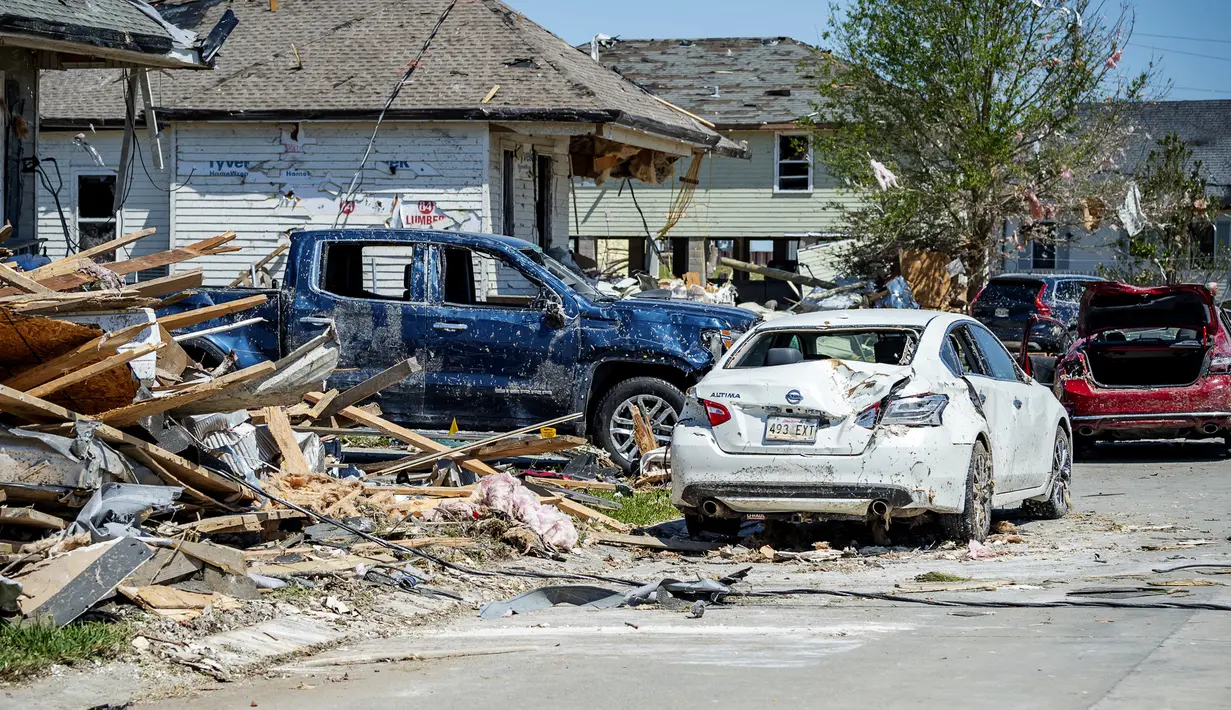 Kendaraan yang rusak diparkir di antara puing-puing dan rumah yang rusak setelah tornado Selasa malam di Arabi, La., Rabu (23/3/2022). (Scott Clause/The Daily Advertiser via AP)