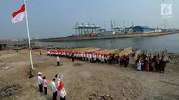 Warga pesisir pantai Cilncing melakukan upacara bendera HUT ke-74 Ri di pinggir pantai, RW 04, Cilincing, Jakarta Utara, Sabtu (17/8/2019). Kegiatan yang diikuti warga RW 08 Manunggal ini diprakarsai Kelas Jurnalistik Cilik dalam rangka memupuk  rasa kebangsaan. (merdeka.com/Arie Basuki)