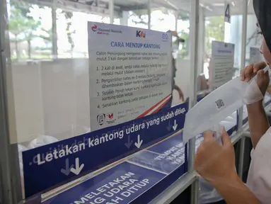 Calon penumpang mengembuskan nafasnya ke dalam kantong untuk dites COVID-19 dengan GeNose C19 di Stasiun Gambir, Jakarta, Rabu (24/3/2021). PT KAI (Persero) menaikkan tarif pemeriksaan tes GeNose C19 di sejumlah stasiun dari Rp20 ribu menjadi Rp30 ribu. (Liputan6.com/Faizal Fanani)