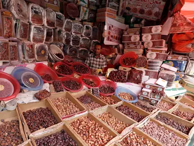 Pedagang kurma menunggu pembeli selama bulan suci Ramadan di sebuah pasar di ibukota Sanaa, Yaman (22/5). (AFP Photo/Mohammed Huwais)