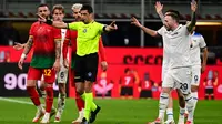 Wasit Gianluca Manganiello (tengah) memberi isyarat di samping bek AC Milan Kyle Walker (kiri) dan gelandang Lazio Manuel Lazzari saat pertandingan ke- 27 Serie A Italia 2024/2025 di stadion San Siro, Milan, pada Minggu 2 Maret 2025 waktu setempat atau Senin (3/3/2025) dini hari WIB. (Piero CRUCIATTI/AFP)