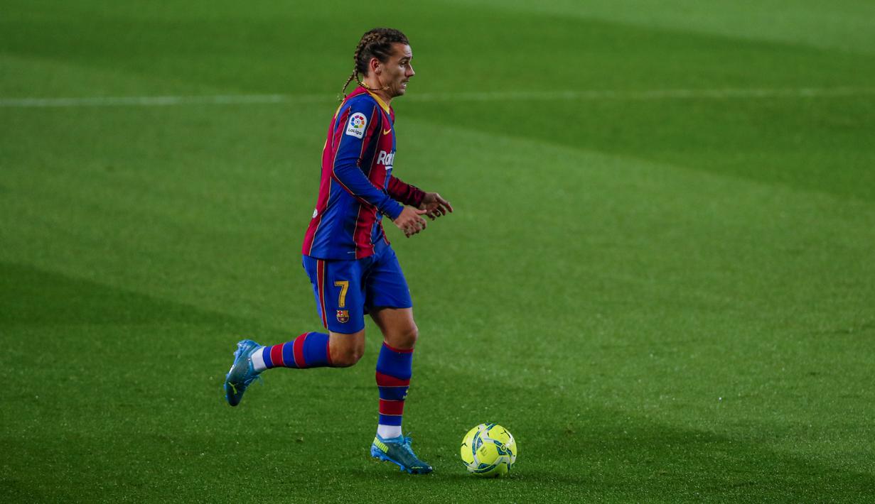 Penyerang Barcelona, Antoine Griezmann menggiring bola saat berhadapan dengan Real Sociedad pada pertandingan lanjutan La Liga Spanyol di stadion Camp Nou di Barcelona, Spanyol, Kamis (17/12/2020). Griezmann megepang dua rambutnya bisa jadi dia mulai bahagia di Barcelona. (AP Photo/Joan Monfort)