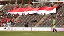 Pendukung Indonesia membentangkan bendera Merah Putih raksasa saat laga kedua Grup A Sepak Bola SEA Games 2023 antara Timnas Indonesia melawan Timnas Myanmar di Olympic Stadium, Phnom Penh, Kamboja, Kamis (04/05/2023). Skuad asuhan Indra Sjafri tersebut berhasil menang dengan skor telak 5-0. (Bola.com/Abdul Aziz)