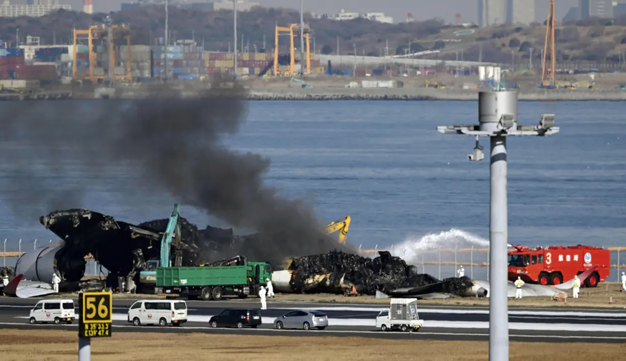 Tabrakan malam itu menyebabkan bola api dan asap hitam muncul di bawah pesawat Japan Airlines saat melaju di landasan pacu setelah menabrak pesawat penjaga pantai di landasan. (Kyodo News via AP)