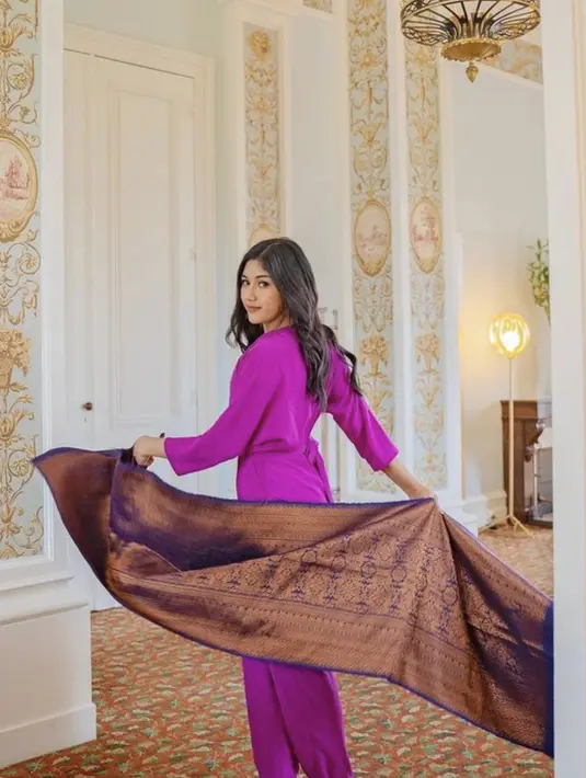 Kali ini, ia juga memamerkan kain tenun dengan nuansa glamor yang tak terbantahkan. Berpadu jumpsuit ungu, Erina memberikan referensi gaya berbeda yang segar dalam OOTD yang ditampilkan. [Foto: Instagram/ Erina Gudono]
