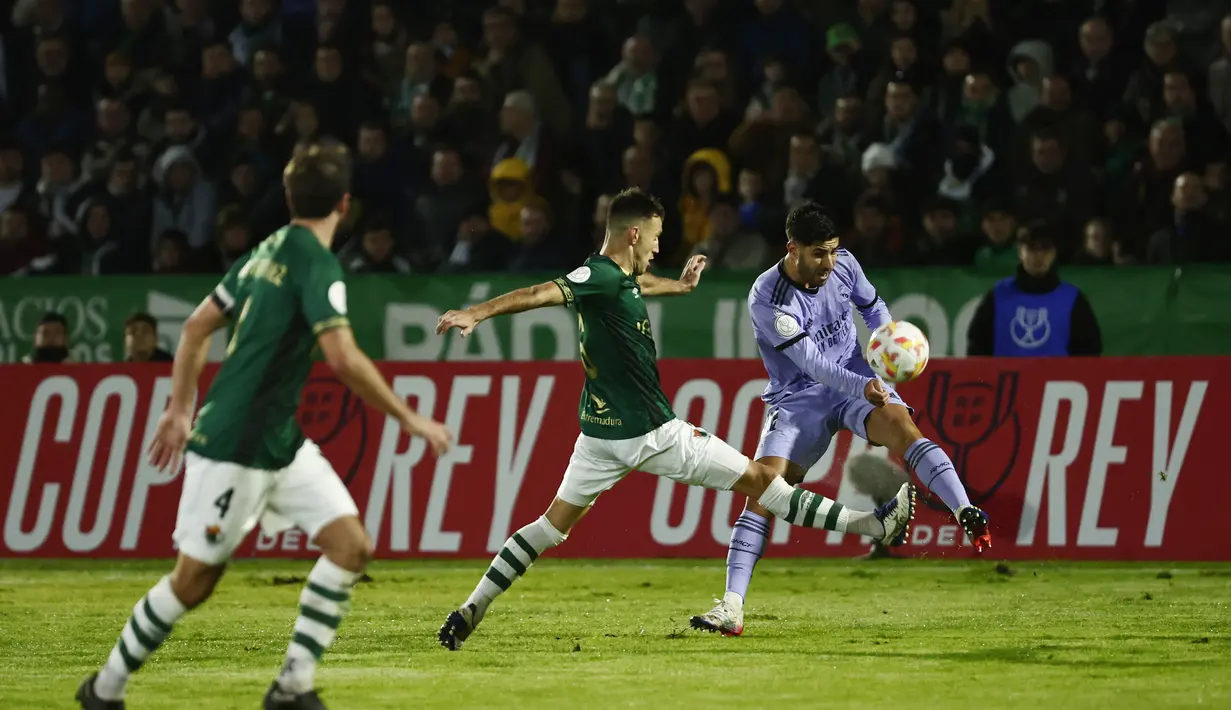 Gelandang Real Madrid, Marco Asensio mencoba untuk mengumpan bola saat bertanding melawan Cacereno selama pertandingan babak 32 besar Copa del Rey di stadion Principe Felipe di Caceres, Spanyol, Rabu (4/1/2023). Real Madrid menang tipis atas Cecereno dengan skor 1-0. (AP Photo/Pablo Garcia)