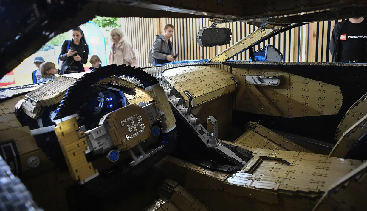 Pengunjung mengamati replika mobil Bugatti Chiron dari jutaan balok Lego Technic pada sebuah pameran di Taman Gorky Moskow, Selasa (23/7/2019). Mobil berwarna biru tersebut dibuat menggunakan lebih dari 1 juta blok Lego Technic dengan berat totalnya sekitar 1.500 kg. (Alexander NEMENOV/AFP)