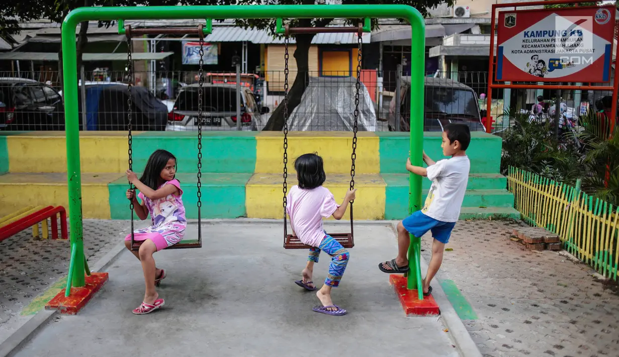 Anak-anak bermain ayunan di Ruang Publik Terbuka Ramah Anak (RPTRA) Rusun Petamburan, Jakarta, Selasa (9/10). Pemprov DKI Jakarta memangkas anggaran pembangunan RPTRA. (Liputan6.com/Faizal Fanani)