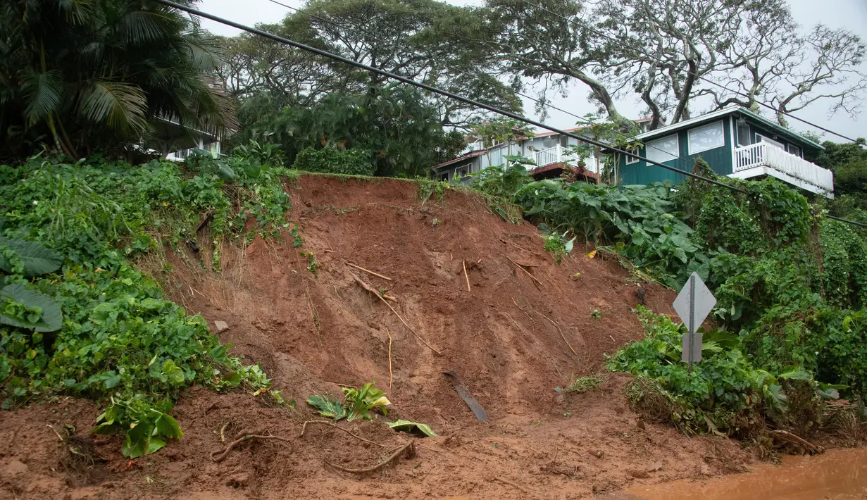 Tanah longsor menutup jalan Raya Kamehameha yang dilapisi dekat Pokole di Kahaluu, Hawaii (9/3/2021). Hujan lebat membuat wilayah tersebut banjir dan dilanda tanah longsor. Warga juga khawatir akan tak berfungsinya bendungan di pulau itu. (Craig T. Kojima/Honolulu Star-Advertiser via AP)