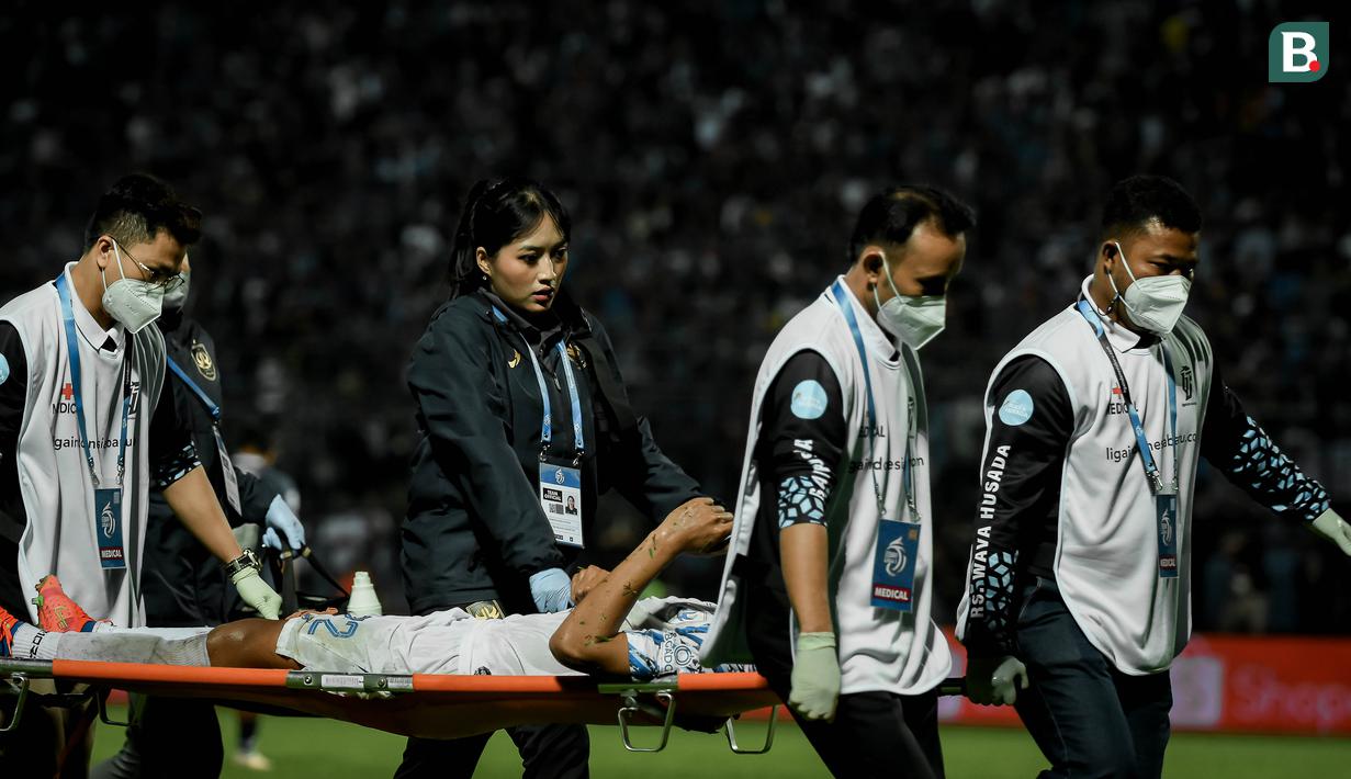 dr Mufida Rizqiyani Husna (dua kiri) mendampingi salah satu pemain PSIS Semarang yang ditandu keluar lapangan saat melawan Arema FC pada pekan kedua BRI Liga 1 2022/2023 di Stadion Kanjuruhan, Malang, Sabtu (30/7/2022). (Bola.com/Iwan Setiawan)