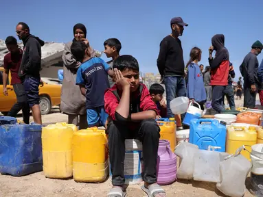 Warga Palestina berusaha mengambil air di sebuah kamp untuk para pengungsi di Kota Gaza, pada tanggal 20 Mei 2025, di tengah perang yang sedang berlangsung antara Israel dan gerakan militan Palestina, Hamas. (Bashar Taleb/AFP)