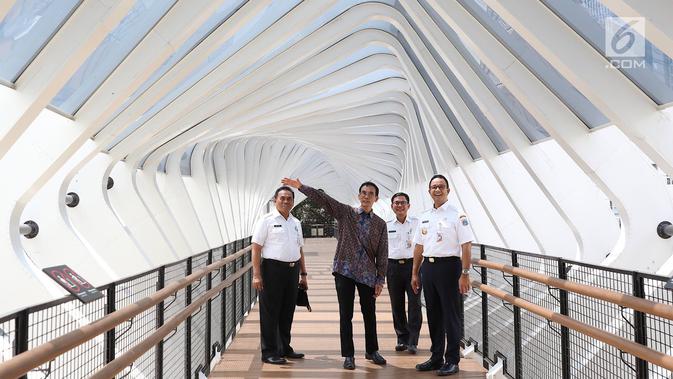 Gubernur DKI Jakarta Anies Baswedan (kanan) mendengarkan penjelasan saat meresmikan jembatan penyeberangan orang (JPO) di Jalan Jenderal Sudirman, Kamis (28/2). Namun, lift JPO masih belum beroperasi ketika diresmikan. (Liputan6.com/Immanuel Antonius)
