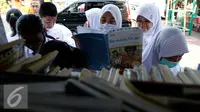 Sejumlah siswa membaca buku dari mobil perpustakaan keliling di halaman sekolah, Jakarta, Jumat (4/9/2015). Sebelumnya sekolah SMPN 49 mengalami kebakaran dan menyebakan ruangkan perpustakaan ludes terbakar. (Liputan6.com/Yoppy Renato)