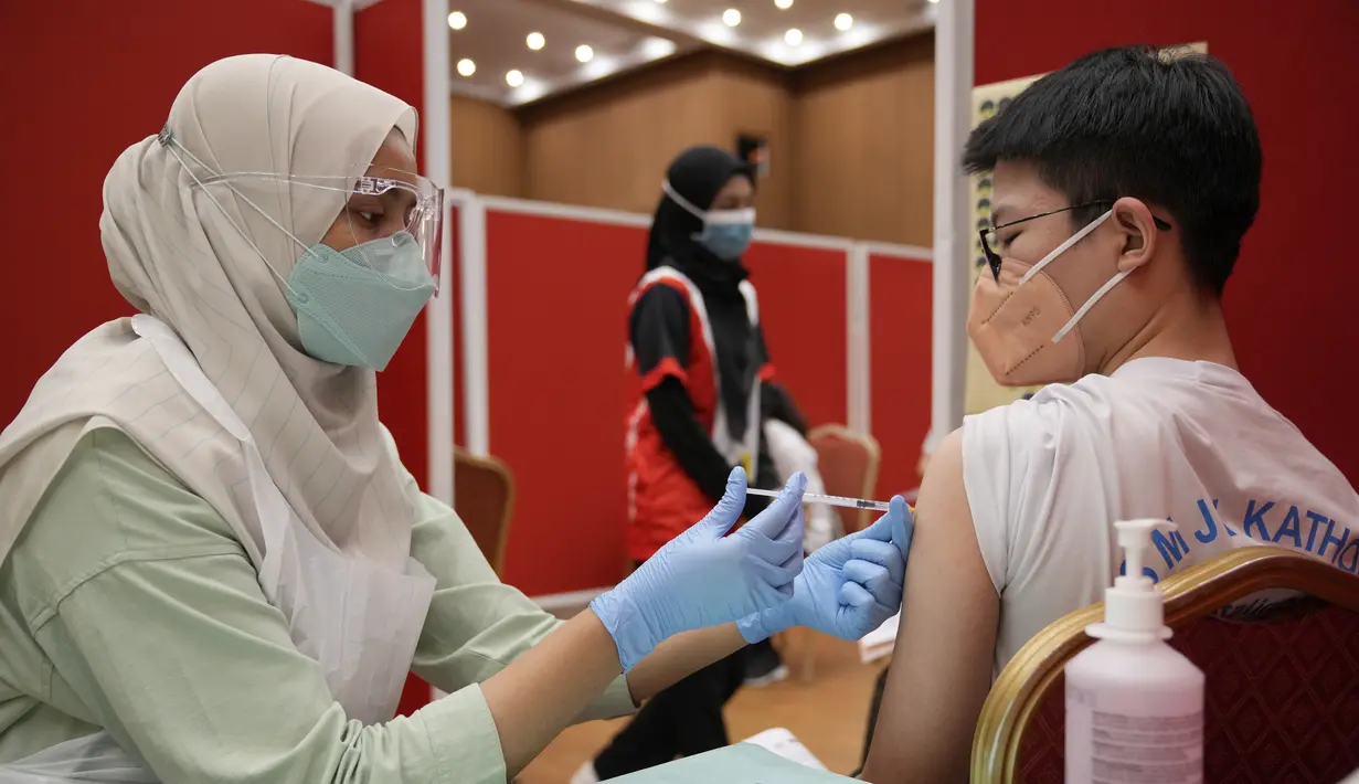 Seorang siswa sekolah menengah menerima dosis vaksin Pfizer terhadap penyakit coronavirus (COVID-19) di pusat vaksin di Shah Alam, Malaysia, Senin (20/9/2021). (AP Photo/Vincent Thian)