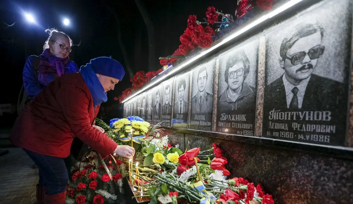 Seorang wanita meletakkan bunga di monumen peringatan 30 tahun bencana nuklir Chernobyl, di kota Slavutych, Ukraina, Selasa (26/4). Ledakan di Chernobyl pada 26 April 1986 silam merupakan kecelakaan terburuk dalam sejarah nuklir. (REUTERS/Gleb Garanich)