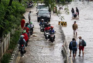 Pengendara dan pejalan kaki melewati perempatan Green Garden, Kedoya, Jakarta, Jumat (3/1/2020). Hingga hari ke-3, banjir masih menggenangi sekitar kawasan perempatan Green Garden, Kedoya akibatnya pengendara harus lebih waspada menghindari mesin kemasukan air. (Liputan6.com/Helmi Fithriansyah)