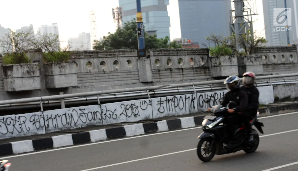 Pengendara motor melintasi jembatan layang Jalan HR Rasuna Said, Jakarta, Selasa (11/7). Dinding pembatas jembatan layang HR Rasuna Said arah kuningan dipenuhi coretan. (Liputan6.com/Helmi Fithriansyah)